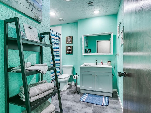 bathroom with vanity, a textured ceiling, and toilet