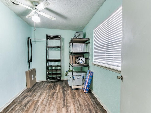 interior space featuring dark hardwood / wood-style floors, ceiling fan, and a textured ceiling