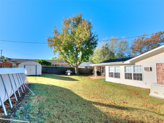 view of yard with a wall unit AC and a storage unit