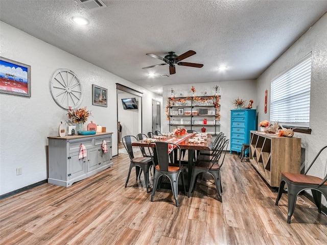 dining space featuring ceiling fan, light hardwood / wood-style flooring, and a textured ceiling