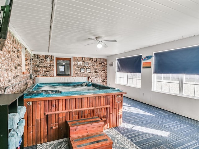 bedroom featuring ceiling fan and brick wall