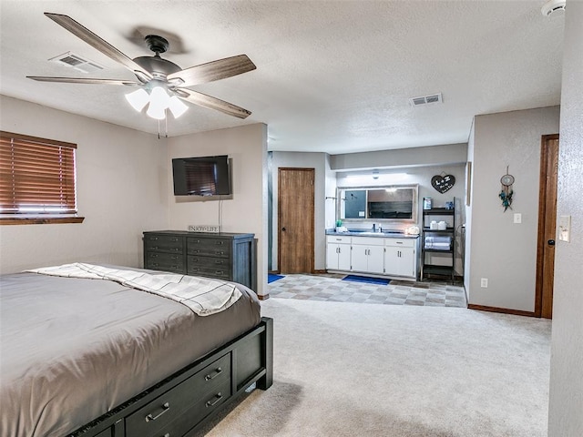 carpeted bedroom featuring ceiling fan, sink, a textured ceiling, and connected bathroom