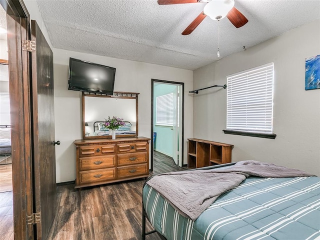 bedroom with a textured ceiling, dark hardwood / wood-style floors, and ceiling fan