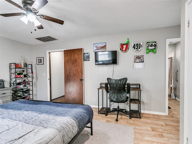 bedroom with light wood-type flooring, a textured ceiling, and ceiling fan