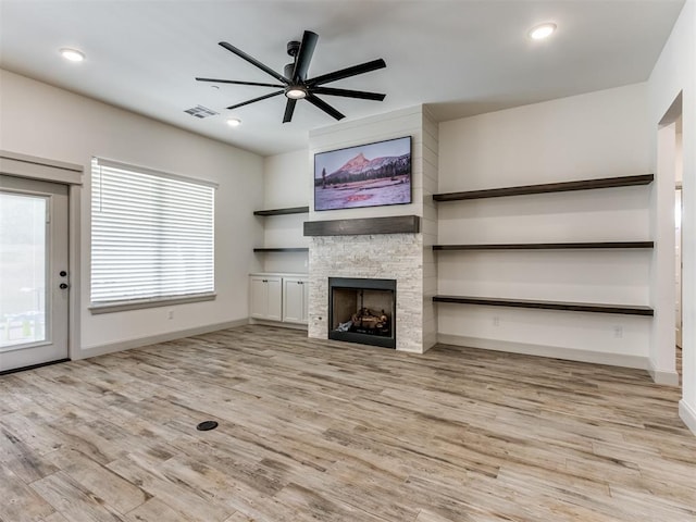 unfurnished living room featuring ceiling fan, a fireplace, and light hardwood / wood-style floors