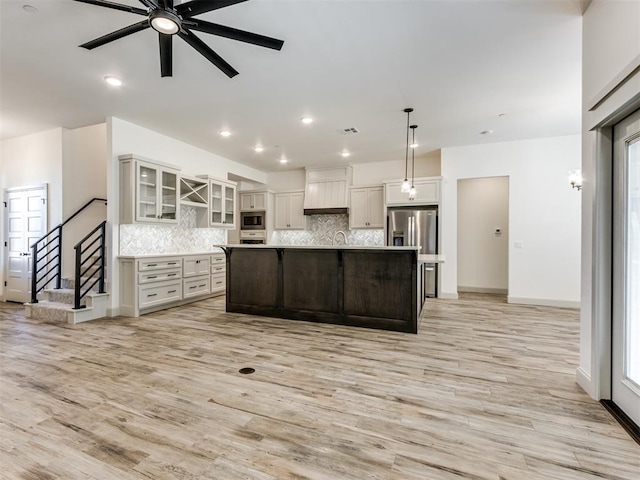 kitchen with pendant lighting, a center island, tasteful backsplash, and appliances with stainless steel finishes