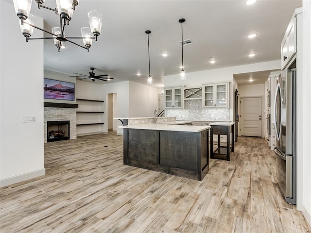 kitchen with backsplash, a center island, white cabinets, and pendant lighting