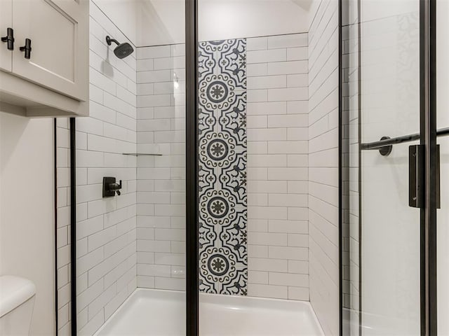 bathroom featuring a tile shower and toilet