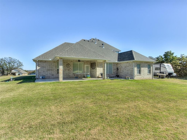 back of property with a lawn, a patio area, and ceiling fan