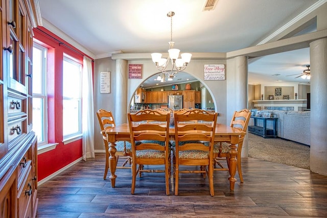 dining area with dark hardwood / wood-style flooring, a healthy amount of sunlight, ceiling fan with notable chandelier, and ornamental molding