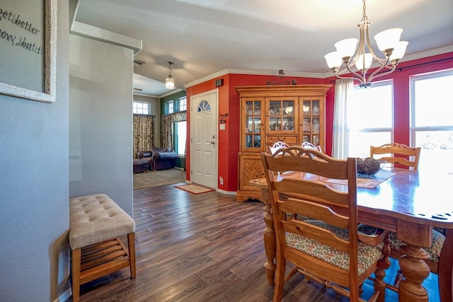 dining area with ornamental molding, a wealth of natural light, dark wood-type flooring, and a notable chandelier