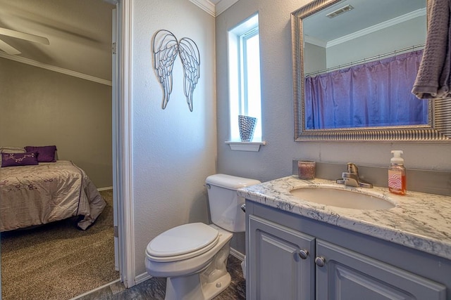 bathroom featuring vanity, toilet, and ornamental molding