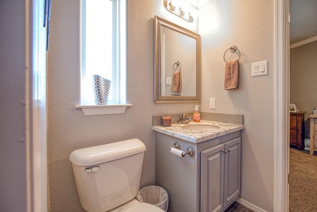 bathroom featuring vanity, toilet, and ornamental molding