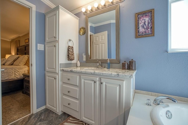 bathroom with a bathtub, hardwood / wood-style floors, vanity, and ornamental molding