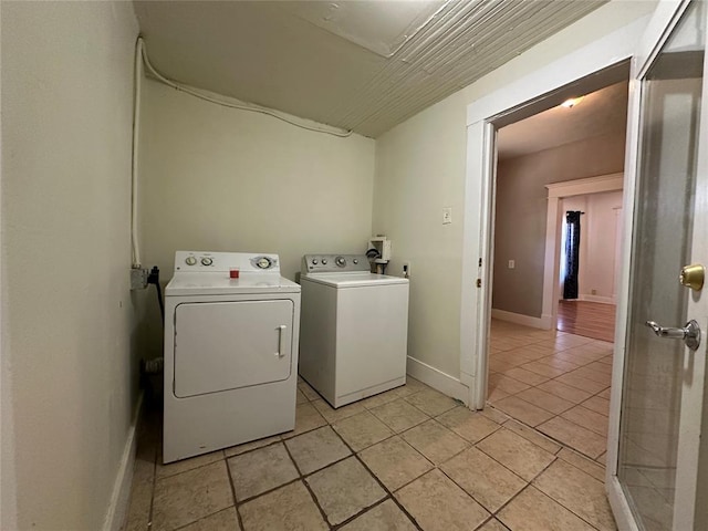 clothes washing area with independent washer and dryer and light tile patterned floors