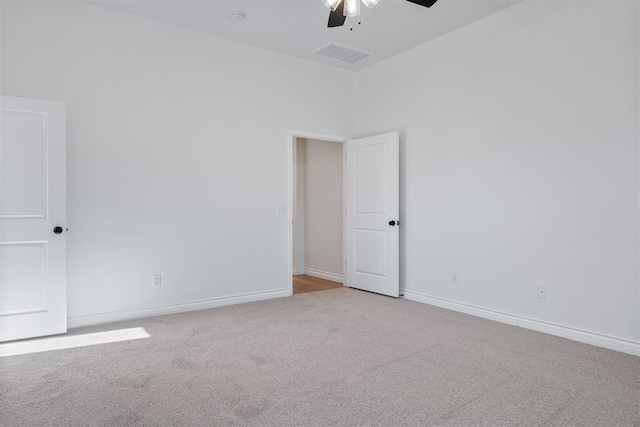 empty room featuring ceiling fan and light colored carpet