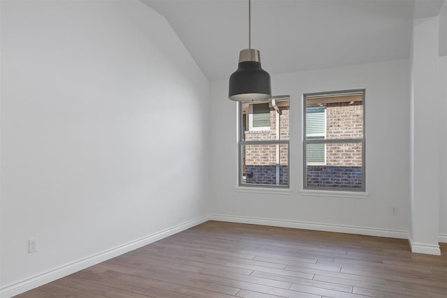 empty room featuring hardwood / wood-style floors and lofted ceiling