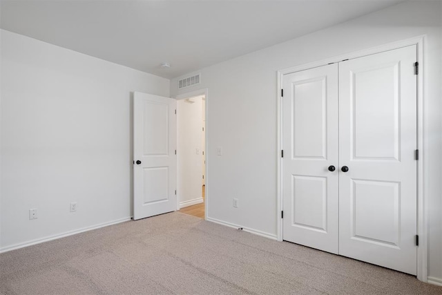 unfurnished bedroom featuring a closet and light carpet