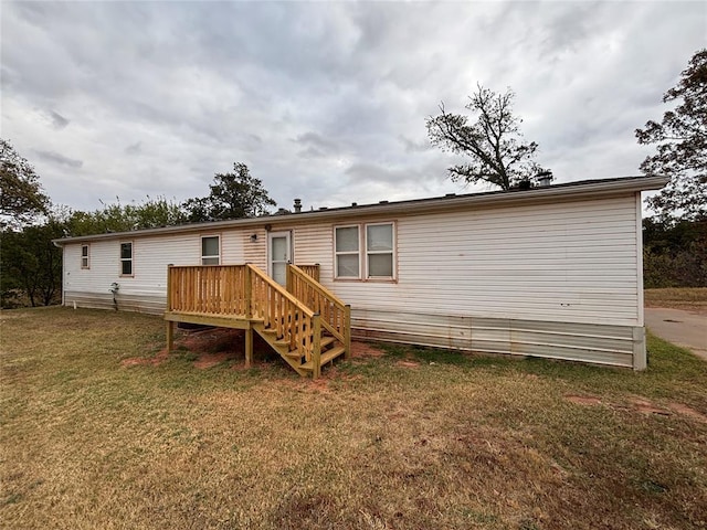 rear view of house with a yard and a deck