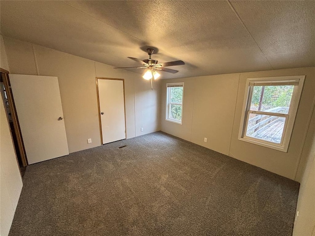 carpeted spare room with ceiling fan and a textured ceiling