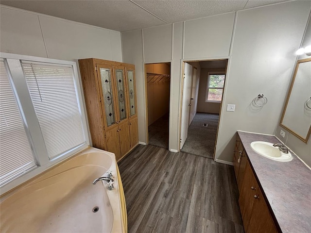 bathroom featuring a bathtub, vanity, wood-type flooring, and a textured ceiling