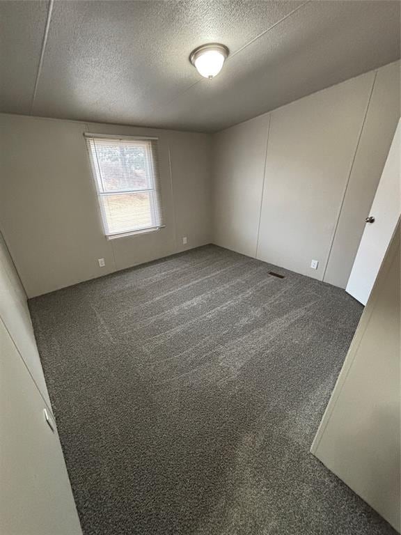 carpeted spare room with a textured ceiling