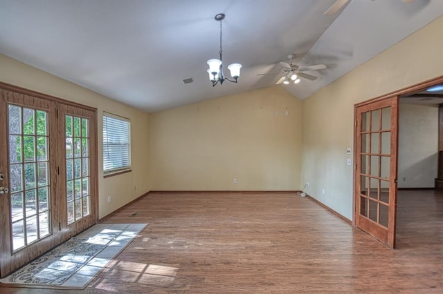 unfurnished room featuring french doors, hardwood / wood-style floors, ceiling fan with notable chandelier, and vaulted ceiling