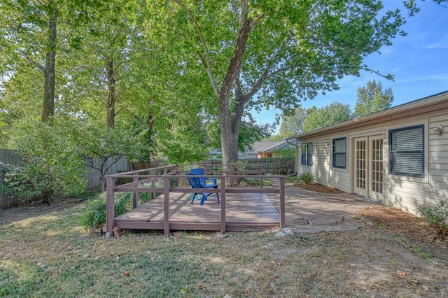 view of yard with french doors, a fenced backyard, and a wooden deck