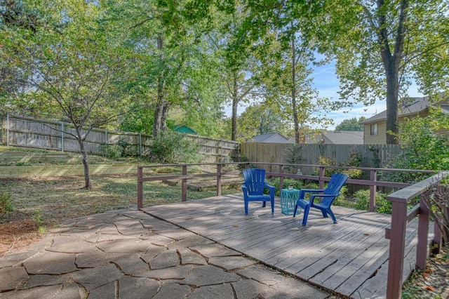 wooden terrace with a fenced backyard