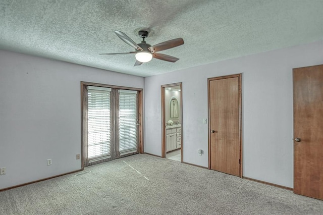 unfurnished bedroom featuring visible vents, light colored carpet, a textured ceiling, ensuite bath, and baseboards