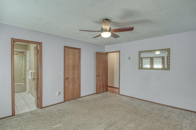 unfurnished bedroom featuring baseboards, connected bathroom, ceiling fan, a textured ceiling, and carpet flooring