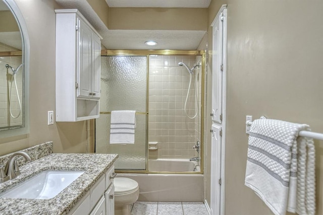 full bath featuring bath / shower combo with glass door, vanity, toilet, and tile patterned floors