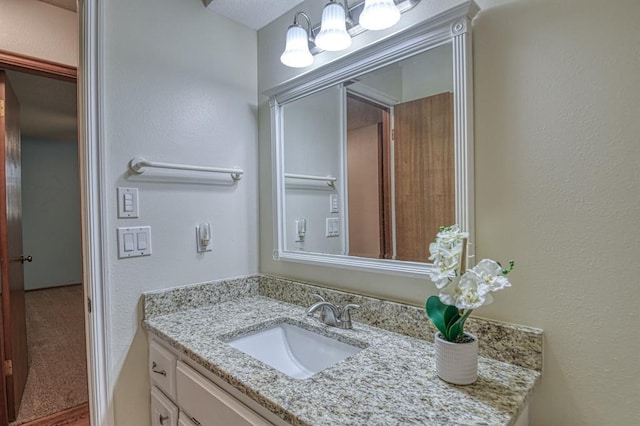 bathroom with a textured wall and vanity