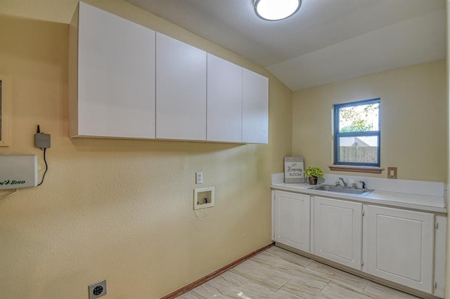 laundry area featuring cabinet space, baseboards, a sink, hookup for a washing machine, and electric dryer hookup