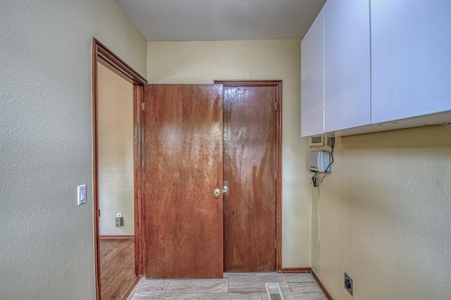 interior space with light wood-style floors, baseboards, and visible vents