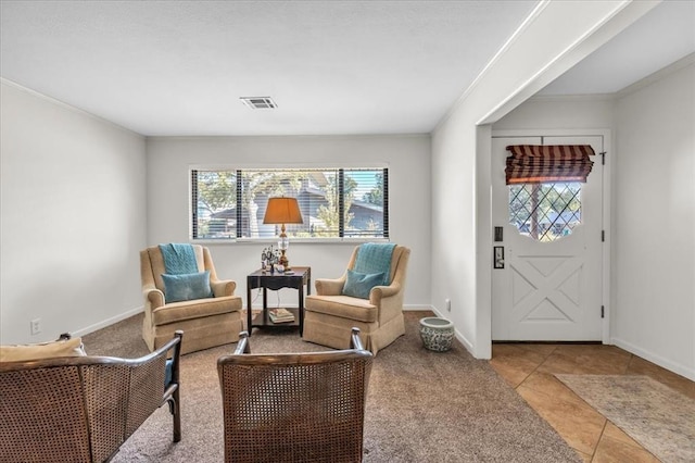 living area featuring ornamental molding and light tile patterned flooring