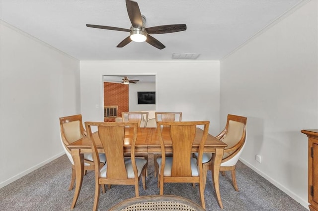 dining space with a brick fireplace, ceiling fan, carpet floors, and ornamental molding