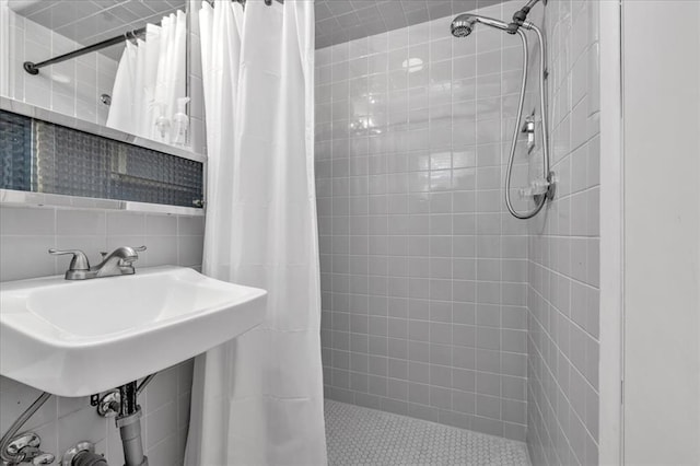 bathroom featuring decorative backsplash, sink, tile walls, and a shower with shower curtain