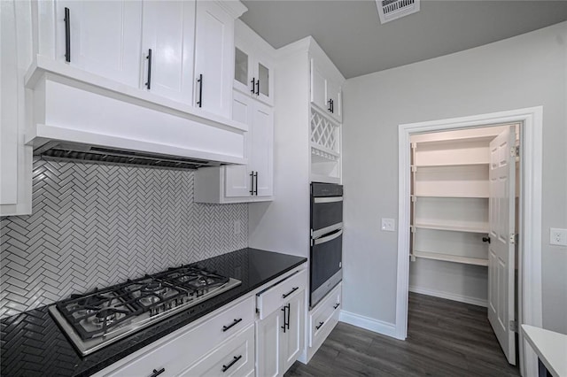 kitchen with custom exhaust hood, backsplash, dark hardwood / wood-style floors, white cabinetry, and stainless steel appliances