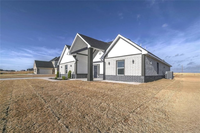 view of front of house featuring central air condition unit and a front lawn