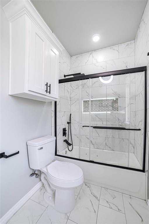 bathroom with toilet and combined bath / shower with glass door