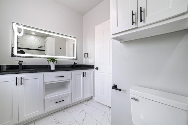 bathroom with walk in shower, vanity, and toilet