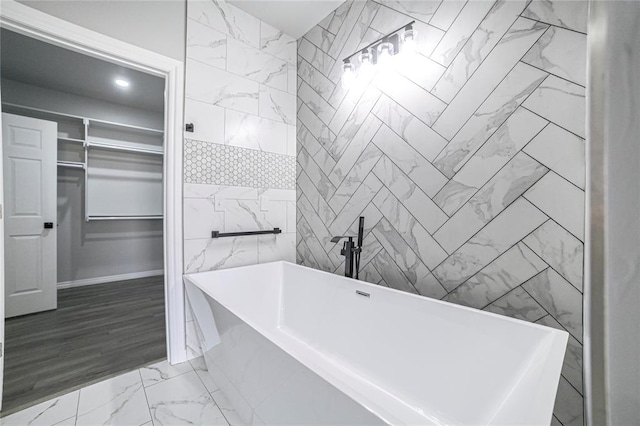 bathroom with a bathing tub, tile walls, and hardwood / wood-style flooring