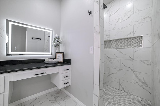 bathroom with tiled shower and vanity