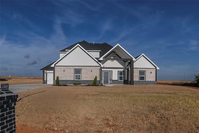 craftsman house featuring a garage and a front lawn