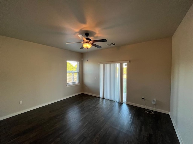 empty room with ceiling fan and dark hardwood / wood-style flooring