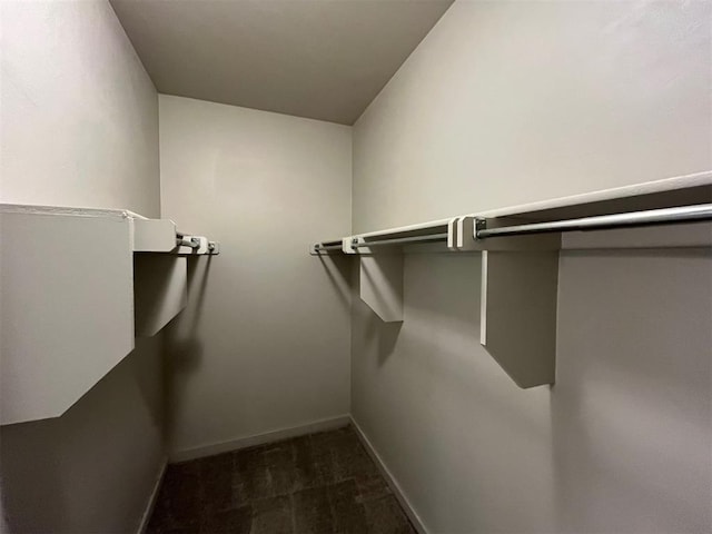 walk in closet featuring dark colored carpet