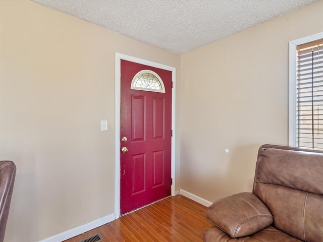 entryway with wood-type flooring and a textured ceiling