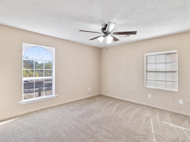 empty room with carpet flooring, ceiling fan, and a textured ceiling