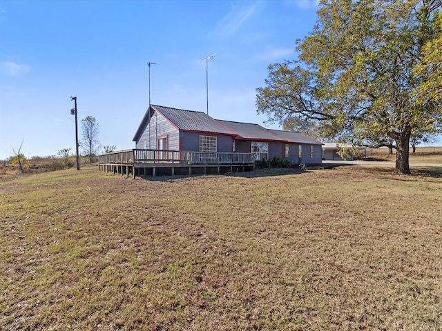 back of house featuring a wooden deck and a yard